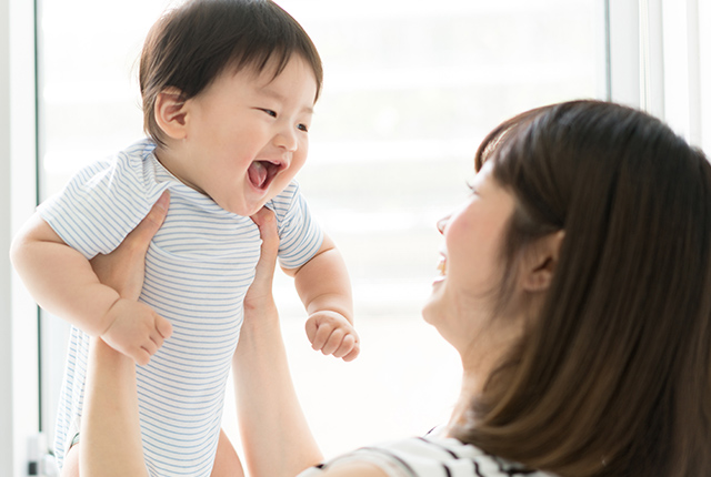 赤ちゃんを抱き上げる女性